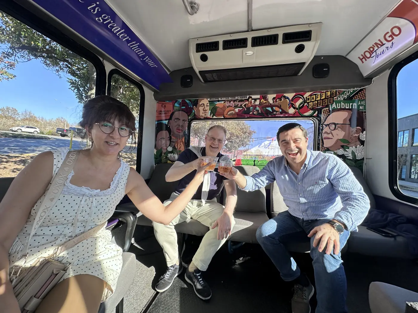Friends toasting with drinks on board the party bus